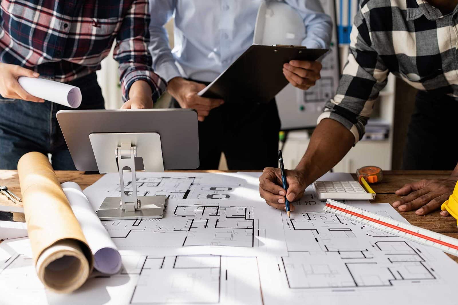 Équipe projet travaillant sur des plans de bureaux